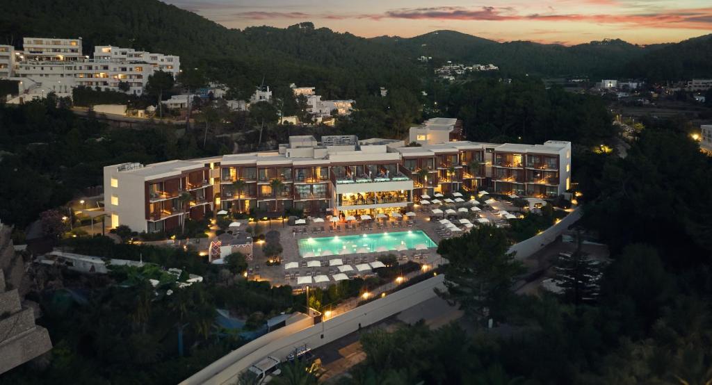 an aerial view of a building with a pool at night at Cala San Miguel Ibiza Resort, Adults only, Curio Collection by Hilton in Puerto de San Miguel