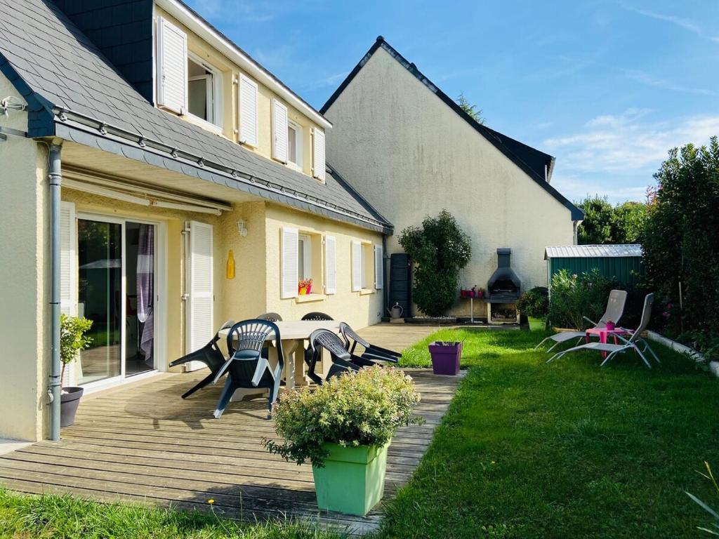 een achtertuin met een houten terras met een tafel en stoelen bij Casa Bords de Loire in Mûrs-Érigné