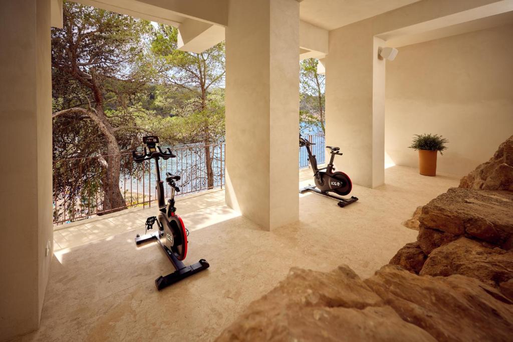 two exercise bikes parked in a room with a window at Cala San Miguel Ibiza Resort, Adults only, Curio Collection by Hilton in Puerto de San Miguel