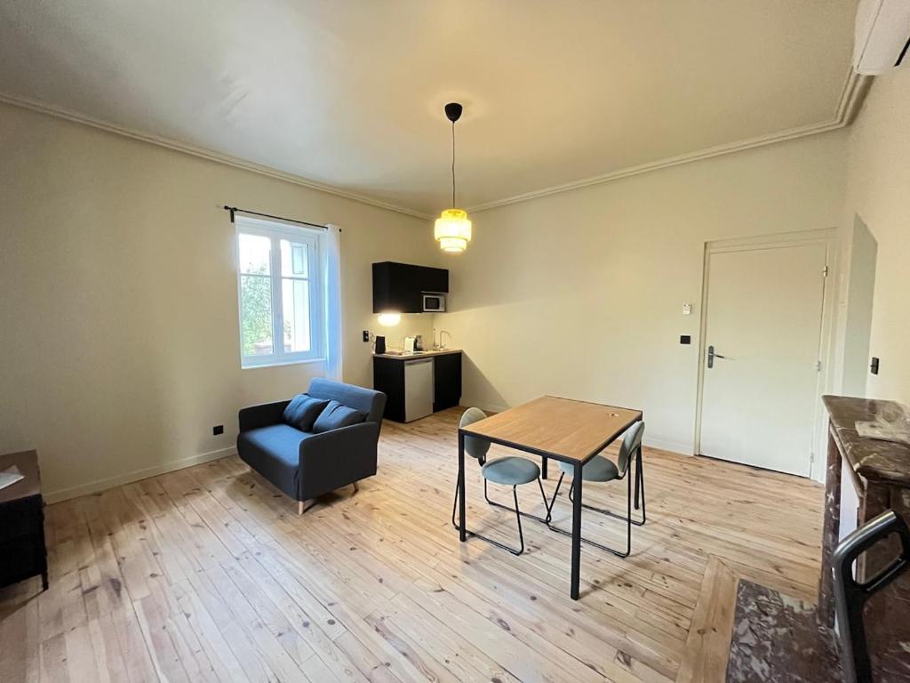 un salon avec une table et une chaise dans l'établissement Studio rénové dans une charmante résidence, à Saint-Étienne