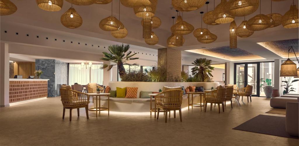 a lobby with a table and chairs and a bar at Cala San Miguel Ibiza Resort, Adults only, Curio Collection by Hilton in Puerto de San Miguel