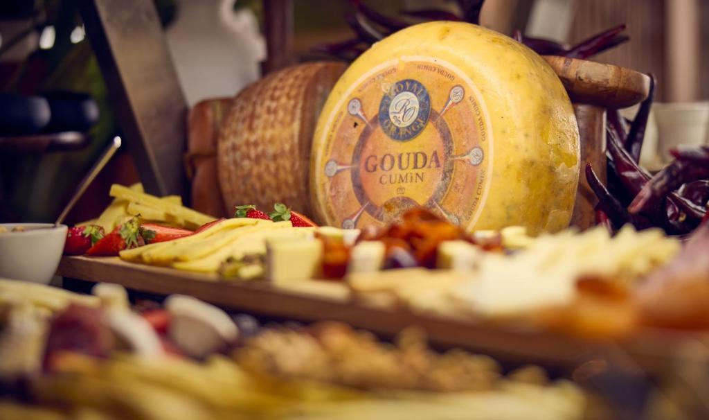 a table with a bottle of cheese and a plate of food at Cala San Miguel Ibiza Resort, Adults only, Curio Collection by Hilton in Puerto de San Miguel