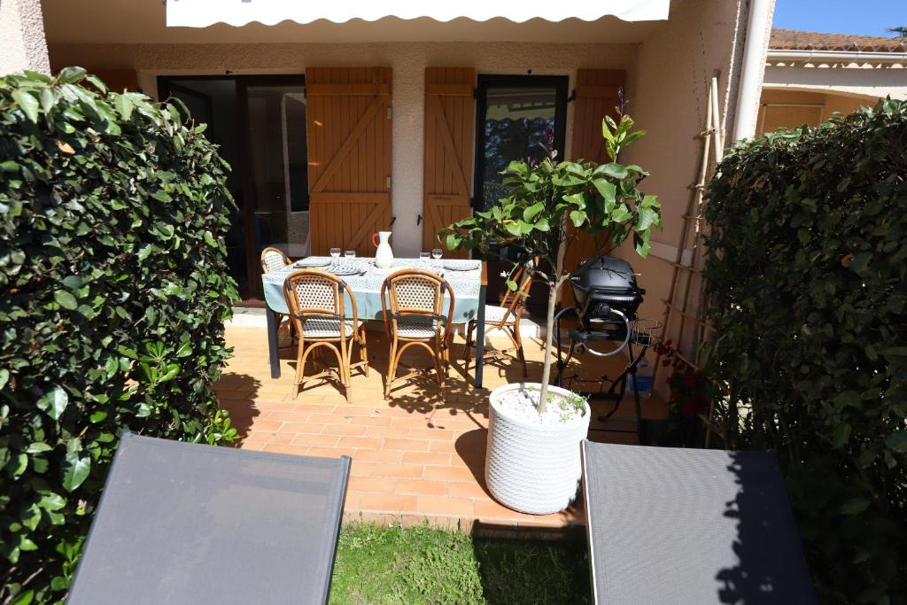- une table et des chaises sur une terrasse dans une maison dans l'établissement St Cyprien charmant rez de jardin 2 velos Piscine, à Saint-Cyprien