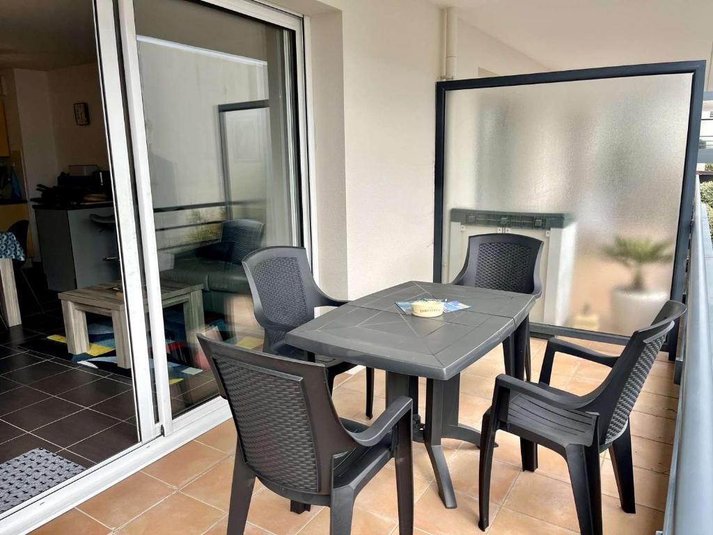 a table and chairs in a room with a window at Étel: Appartement T2, Terrasse Sud, Près du Port, Parking, Animaux Permis - FR-1-479-218 in Étel