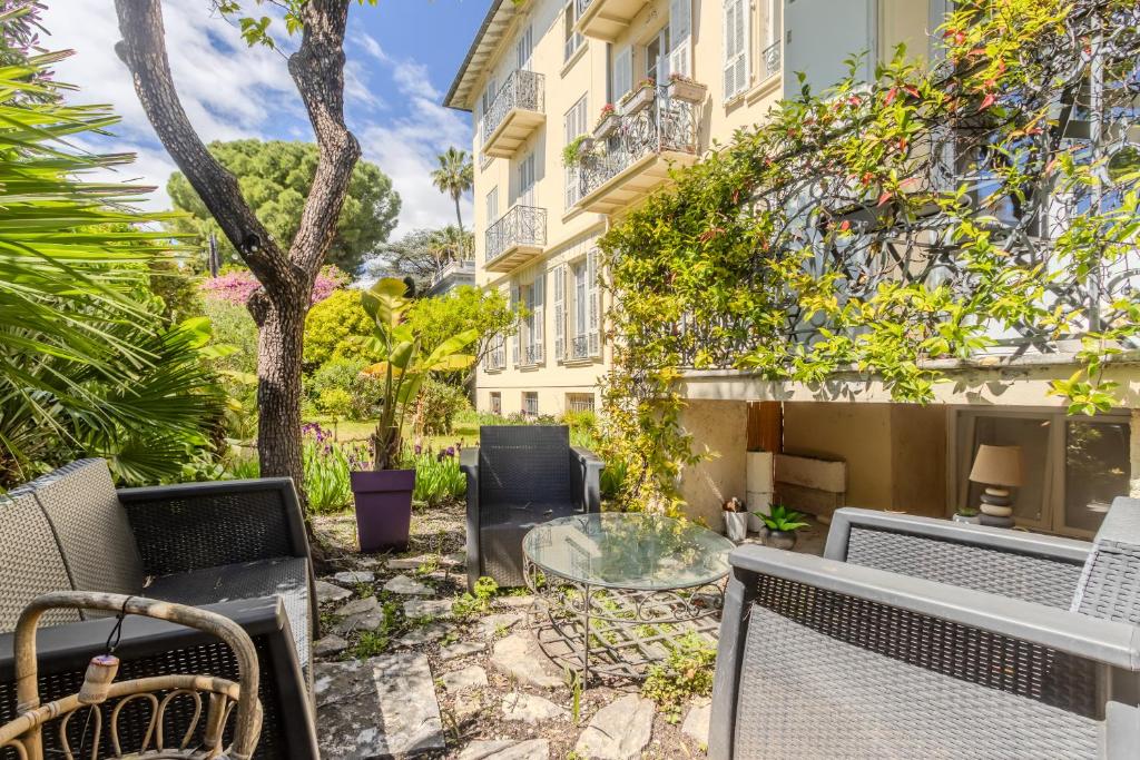 un patio avec des chaises et une table en verre devant un bâtiment dans l'établissement Le coin du Bonheur au port de Nice !, à Nice