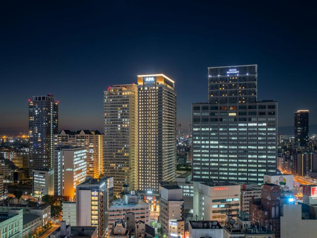 a city skyline with tall buildings at night at APA Hotel & Resort Osaka Namba Ekimae Tower in Osaka