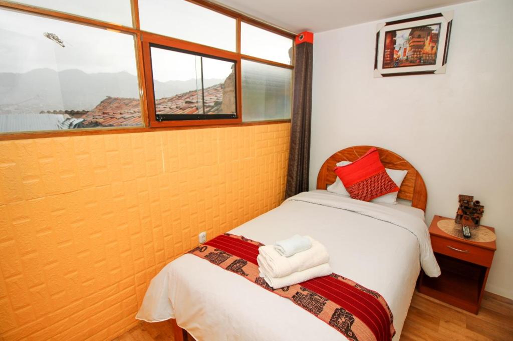 Rúm í herbergi á Cusco Qori Sisa Hostal