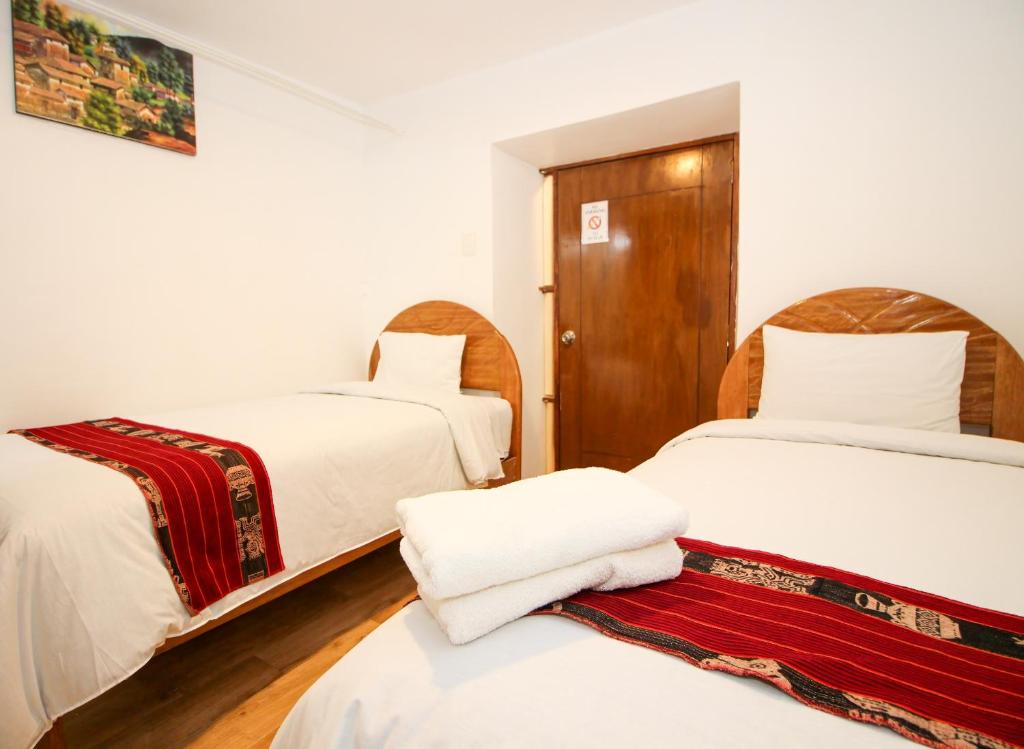 Rúm í herbergi á Cusco Qori Sisa Hostal