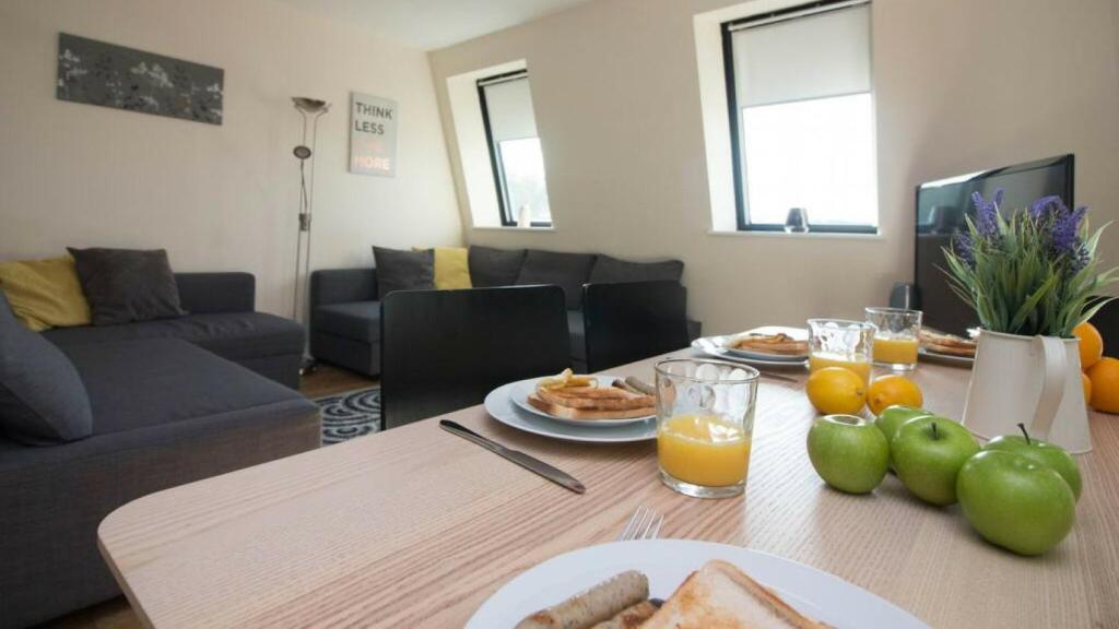 a living room with a table with a plate of food at StayZo Premiere Serviced Accommodation-17 in Southampton