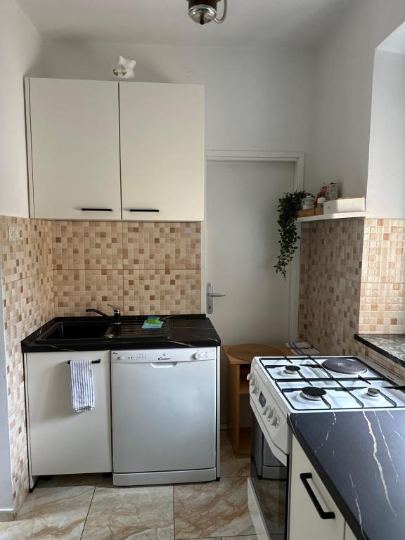 a kitchen with white cabinets and a stove top oven at Apartment Marino in Senj