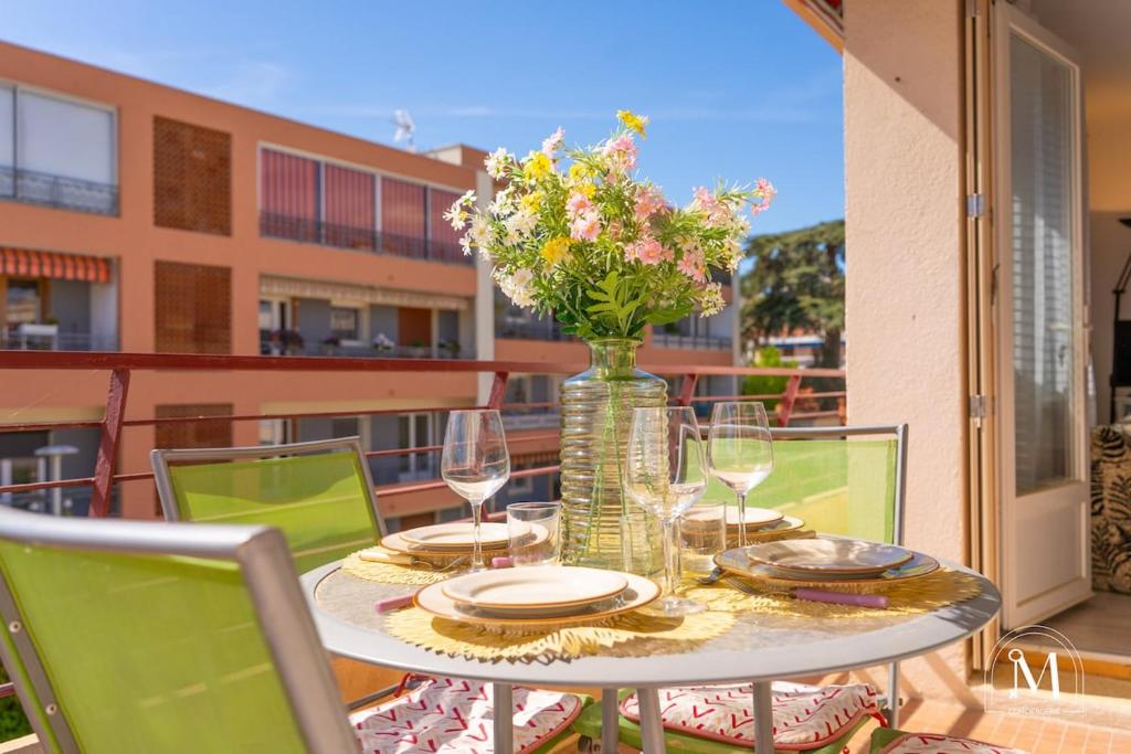 une table avec un vase de fleurs sur un balcon dans l'établissement Spacieux T3 avec parking au coeur de Sanary, à Sanary-sur-Mer