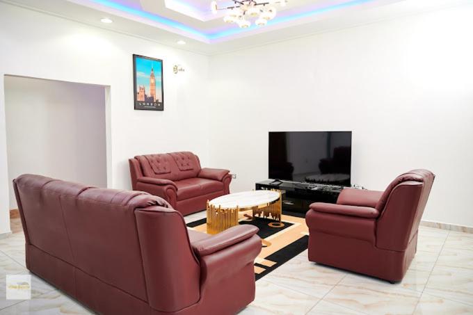 a living room with two chairs and a flat screen tv at Chic villa with pool in Kribi