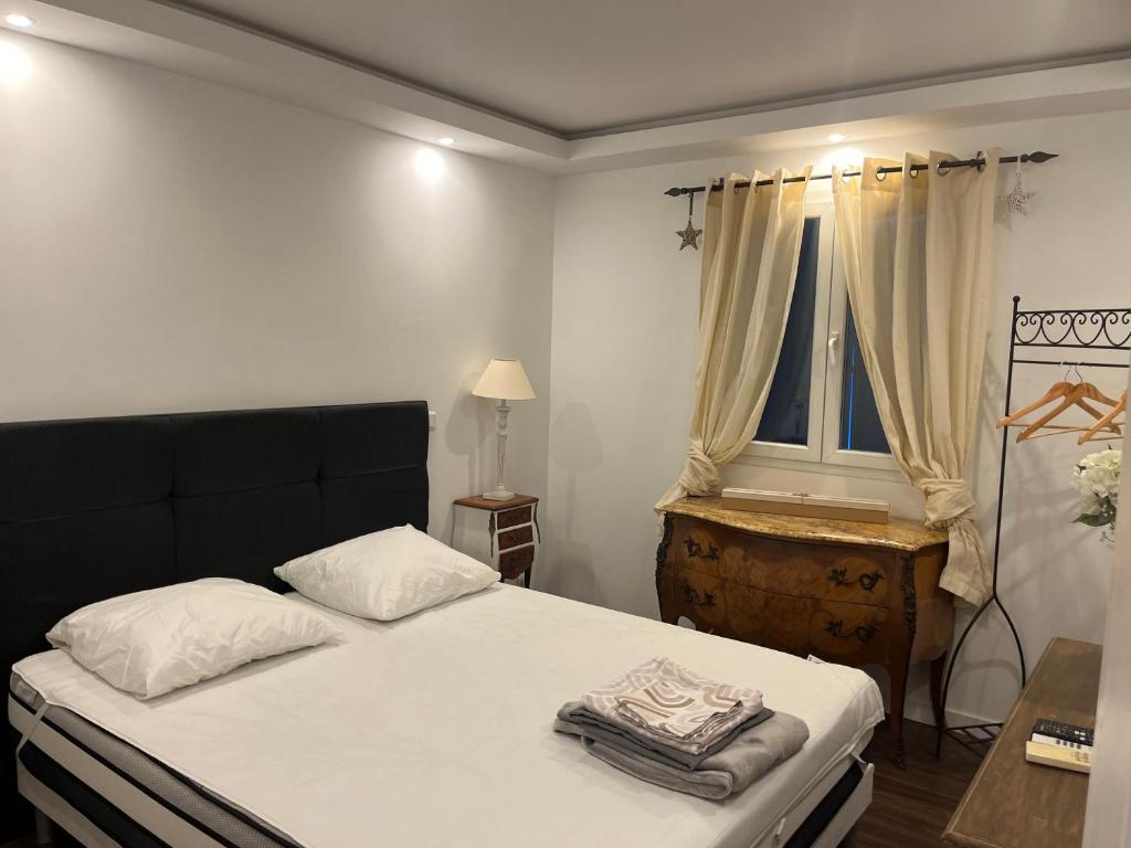 une chambre avec un lit avec des draps blancs et une fenêtre dans l'établissement Villa Bagnols en forêt, à Bagnols-en-Forêt