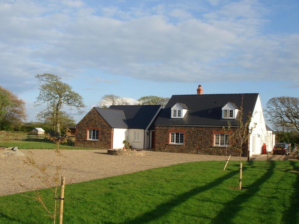 una casa de ladrillo con techo negro en The Paddock, en Haverfordwest