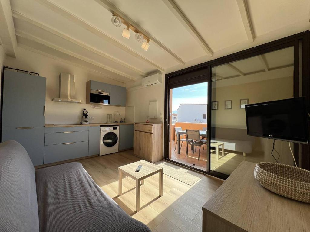 un salon avec un canapé et une cuisine dans l'établissement Appartement T2 Climatise avec Parking proche Plage - FR-1-81-631, à Port-Leucate