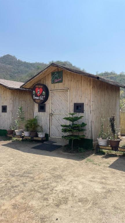 Un edificio con plantas en macetas en frente de él. en Bambooz Bell cottage and camps I Kasauli I Lake View & Trekking, en Kasauli