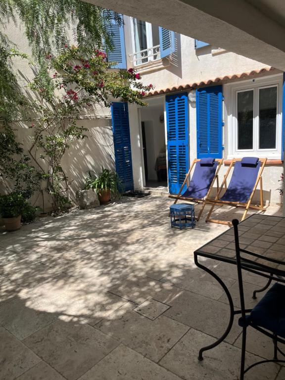 - deux chaises bleues et une table sur une terrasse dans l'établissement Toulon Mourillon mitre mer, à La Celle-sous-Gouzon
