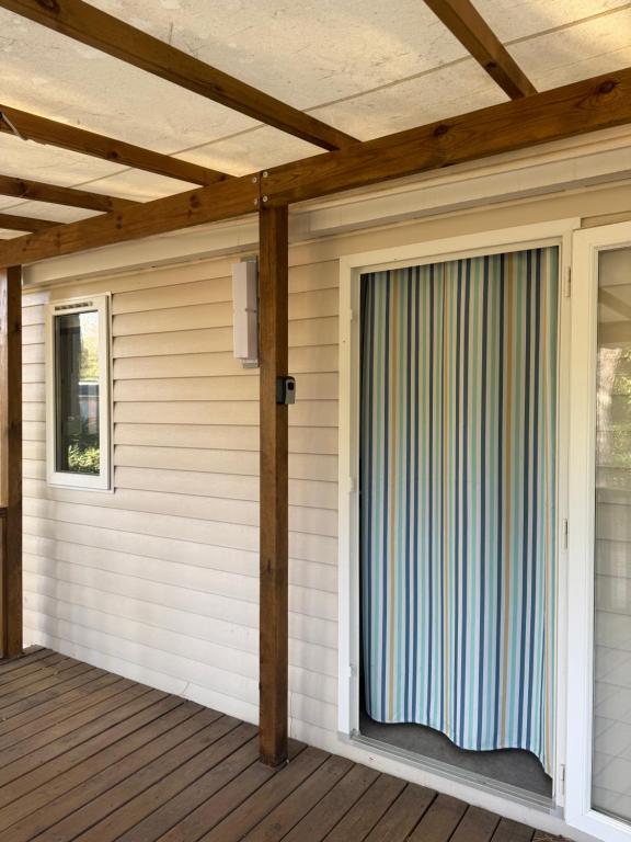Un porche cubierto con una puerta corrediza de vidrio en Mobil home propre et récent, en Argelès-sur-Mer