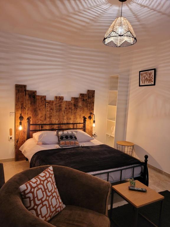 a bedroom with a large bed and a chair at La Gurlanne in Lasséran