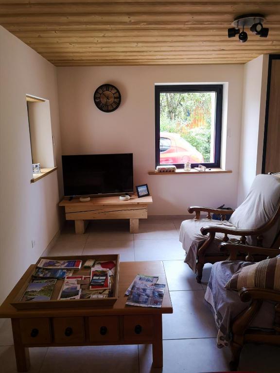 un salon avec une télévision et une table basse dans l'établissement petit gîte des Marolais, à Mont-Saxonnex