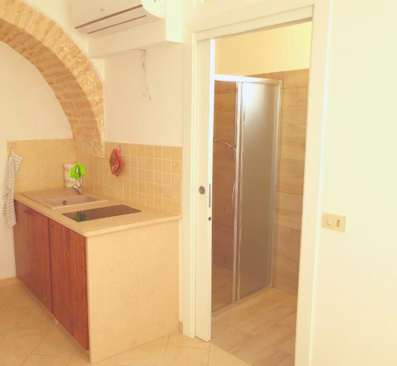 a kitchen with a sink and a shower in a room at Nonna Livia by La Puglia in un trullo in Alberobello
