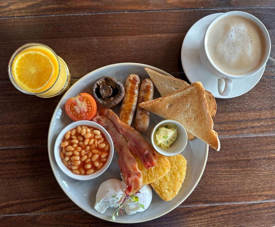 a plate of breakfast food with a cup of coffee at Downs Hotel in Stanmer