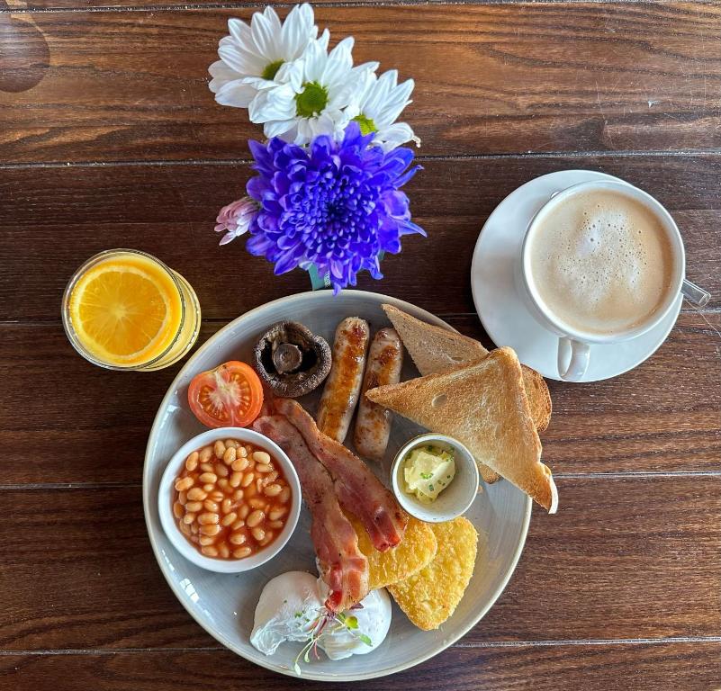 a plate of breakfast food and a cup of coffee at Downs Hotel in Stanmer