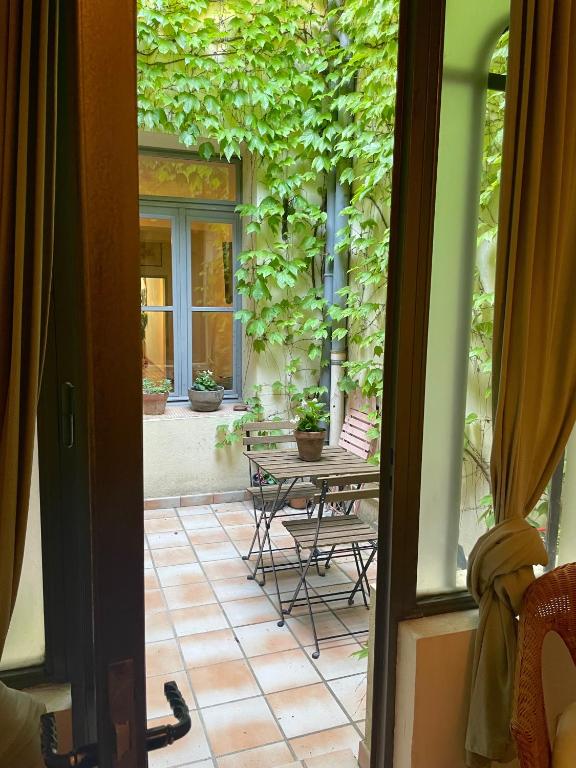 Une porte ouverte s'ouvre sur une terrasse avec une table et des chaises. dans l'établissement Maison aigues-mortaise dans la cité, à Aigues-Mortes