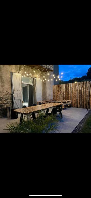 un groupe de tables de pique-nique devant un bâtiment dans l'établissement Chez Louis, à Saint-Flour