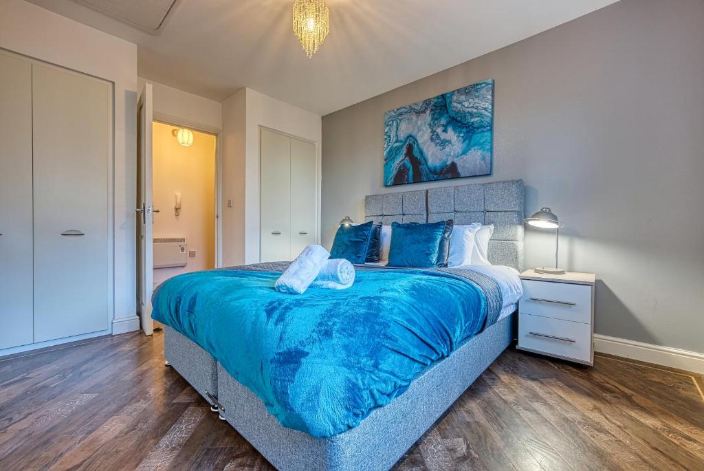 a bedroom with a large bed with a blue comforter at Peaceful 2-Bed in Sutton Coldfield, Near Parks in Sutton Coldfield