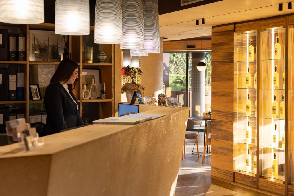 a woman sitting at a bar in a restaurant at Alevic Hotel Sirmione in Sirmione