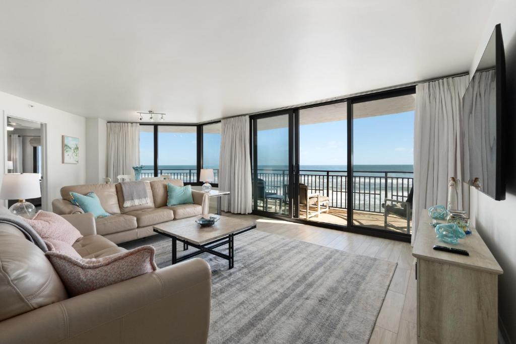 a living room with a couch and a view of the ocean at 3br Condo With Direct Beach View & Large Balcony in Daytona Beach Shores