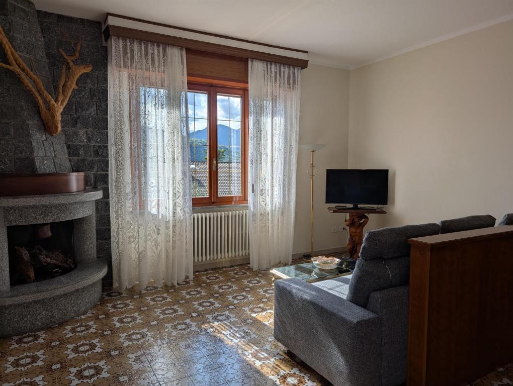 a living room with a couch and a fireplace at Iseo Lake Terrace in Sale Marasino