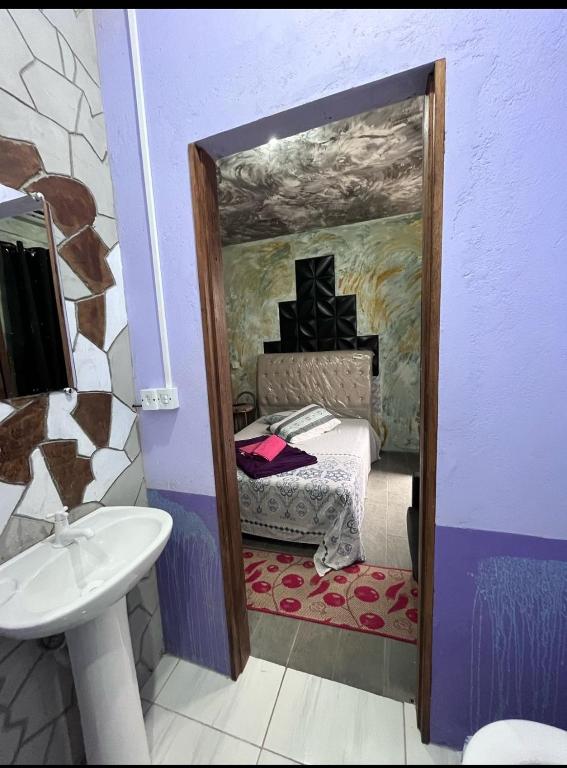 a mirror in a room with a bed and a sink at Hostel Boa Vista in Joinville