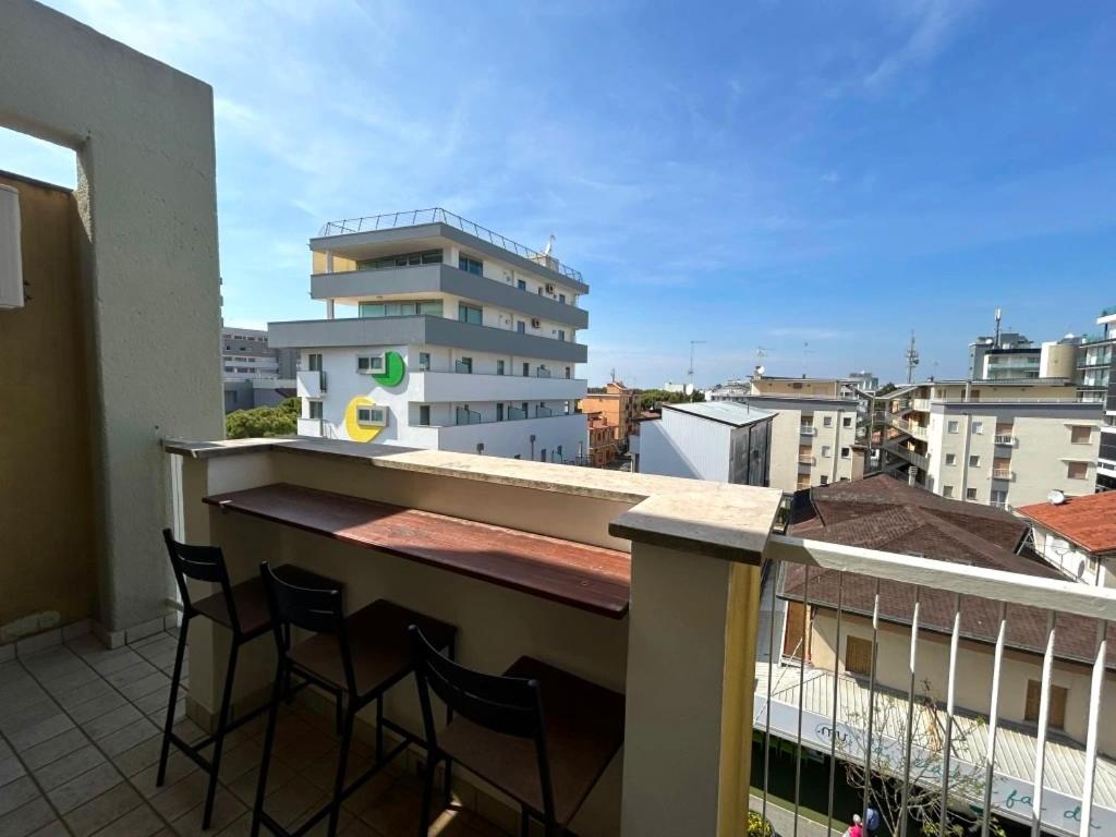 a balcony with chairs and a bar on a building at Central View Loft in Lignano Sabbiadoro