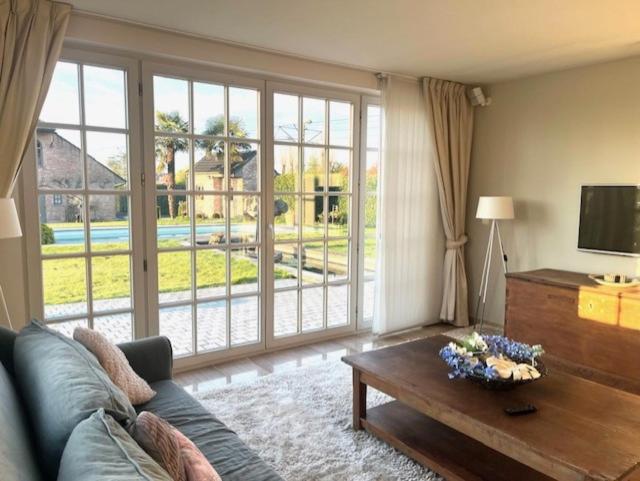 a living room with a couch and a large window at Blauw aan zee in De Panne