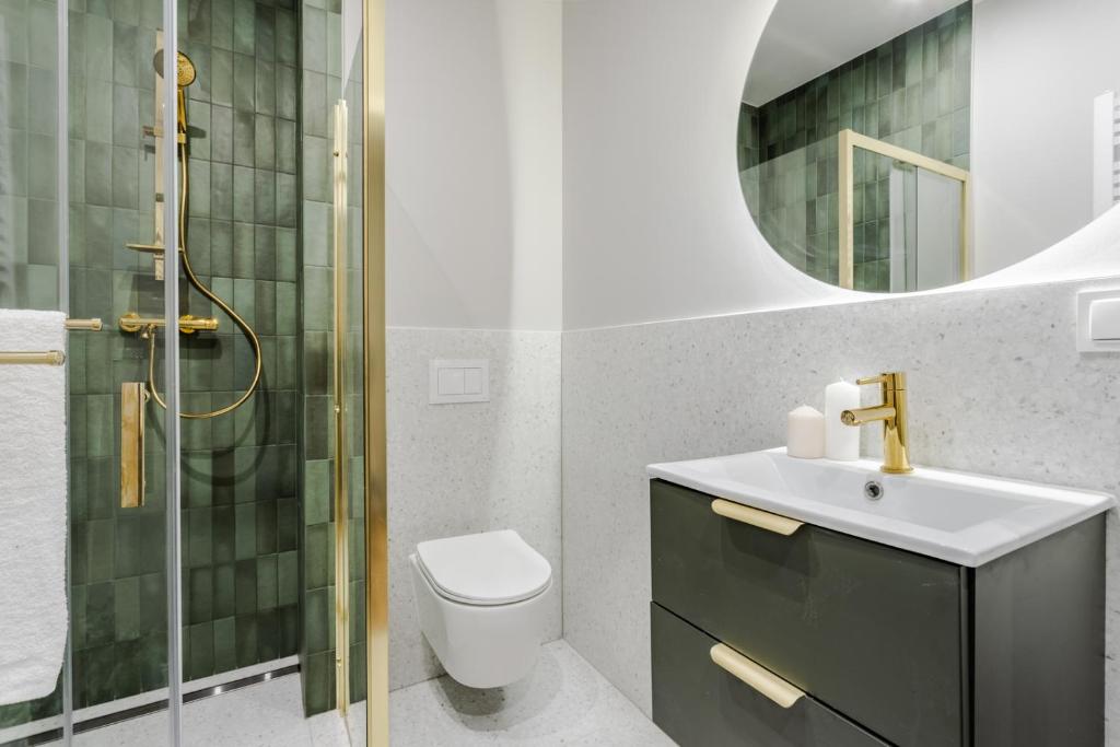 bagno con lavabo, servizi igienici e specchio di GREEN Apartment 2 a Poznań