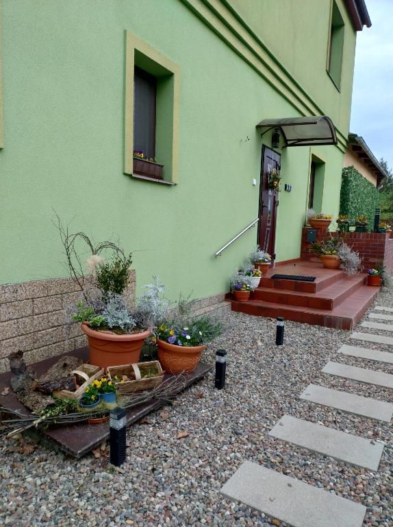 a green building with some plants in front of it at Agroturystyka Magnolia in Cieszyno
