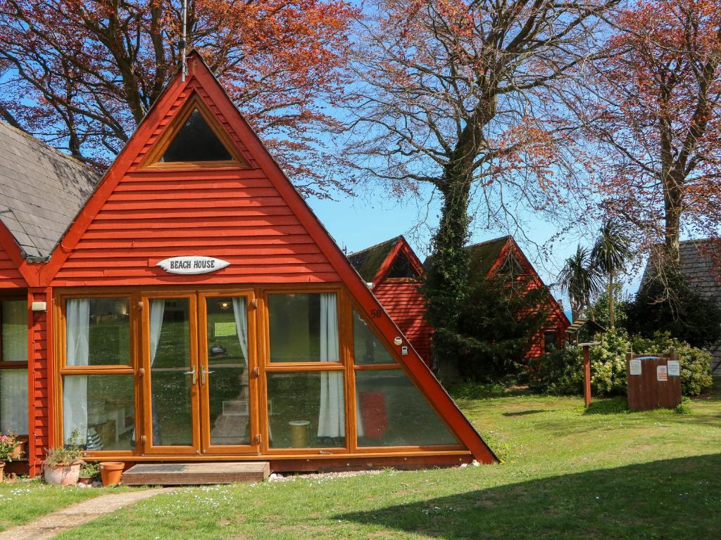 a small red house with a large window at Chalet 58 - The Beach House in Deal