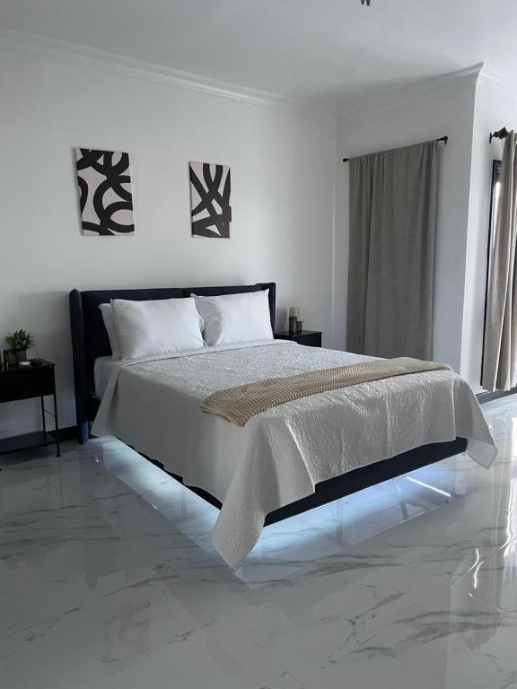 Un dormitorio blanco con una cama grande en una habitación. en Argyle Escape, en Kingston