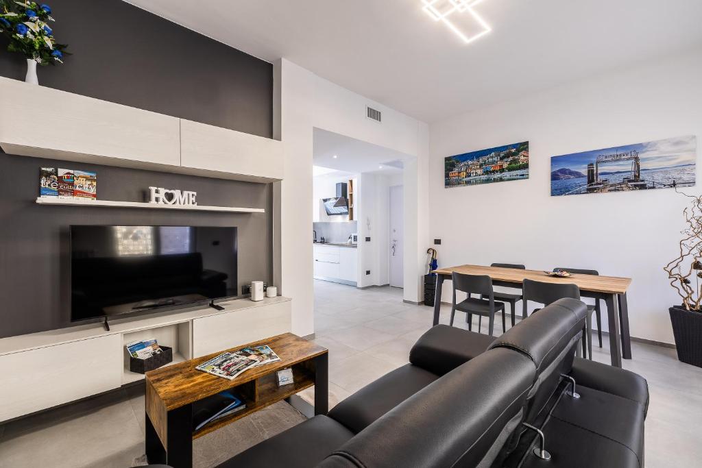 a living room with a couch and a tv and a table at Casa Blue Moon in Baveno