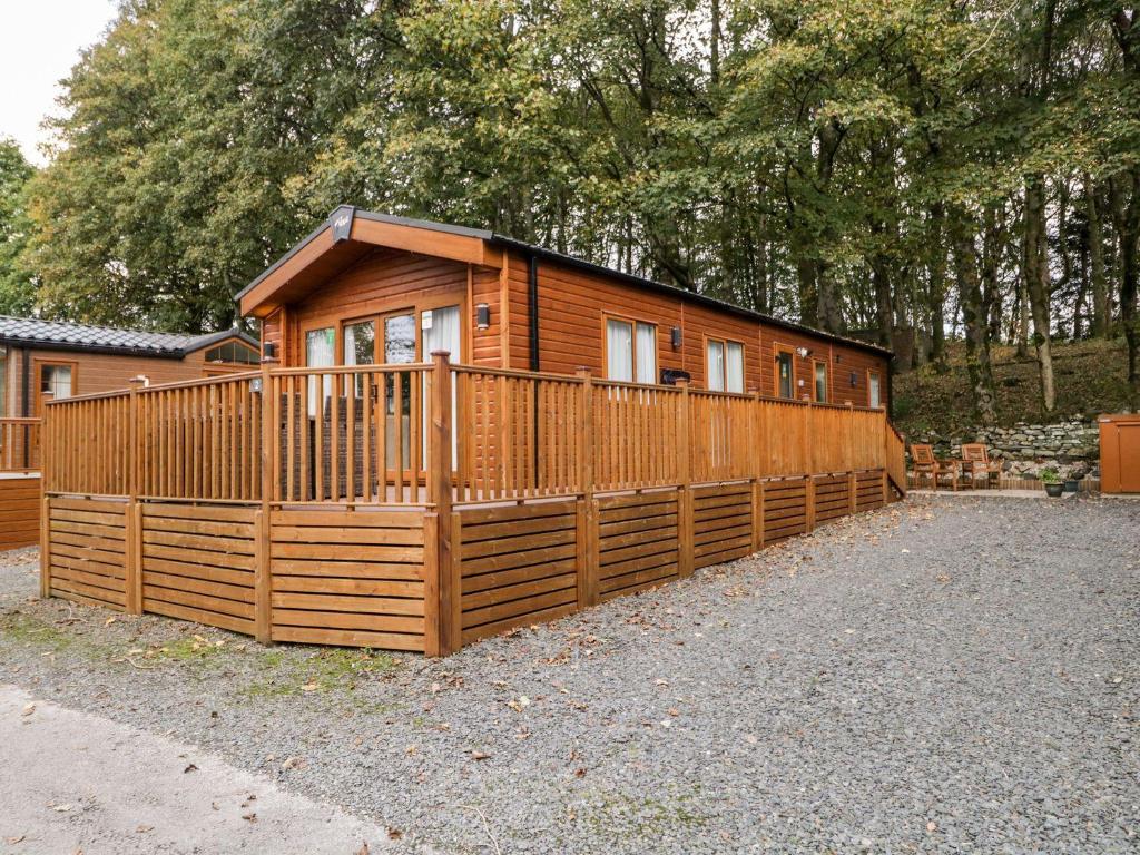 a small wooden cabin with a wooden fence at Water's Reach in Windermere