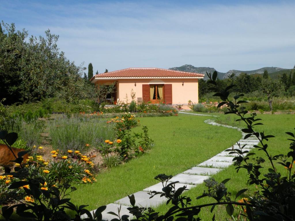 een tuin met een huis op de achtergrond bij S'Arenarju in La Caletta