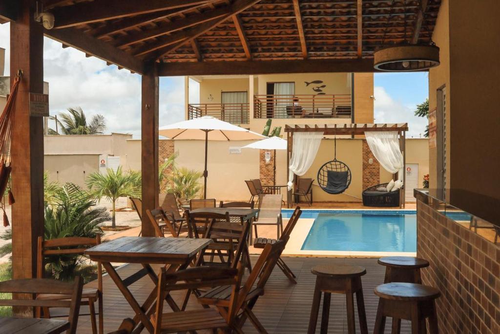 een patio met tafels en stoelen naast een zwembad bij POUSADA RECANTO DAS ÁGUAS Ville in Santo Amaro