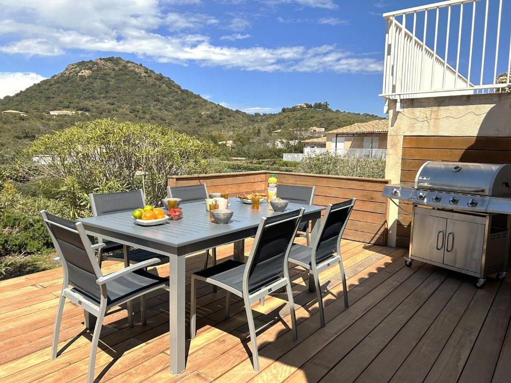 une table et des chaises sur une terrasse avec un grill dans l'établissement Villa 3 chambres dans résidence avec piscine, à Porto-Vecchio