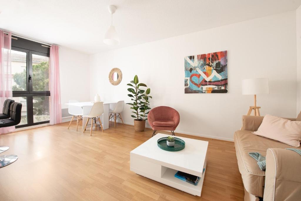 un salon avec un canapé et une table dans l'établissement T2 cosy à 2 pas de la Garonne - Parking privé, à Toulouse