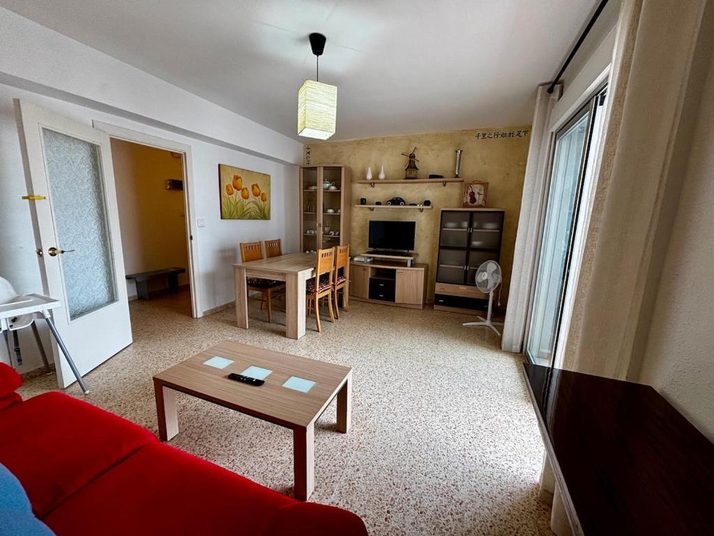 a living room with a red couch and a table at Hermoso piso en la playa in Miramar