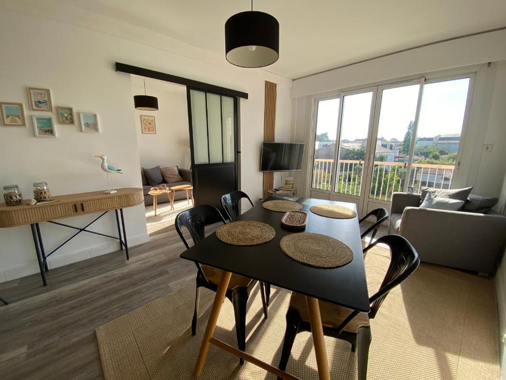 un salon avec une table et des chaises dans une pièce dans l'établissement Le Rochefort, à Les Sables-dʼOlonne