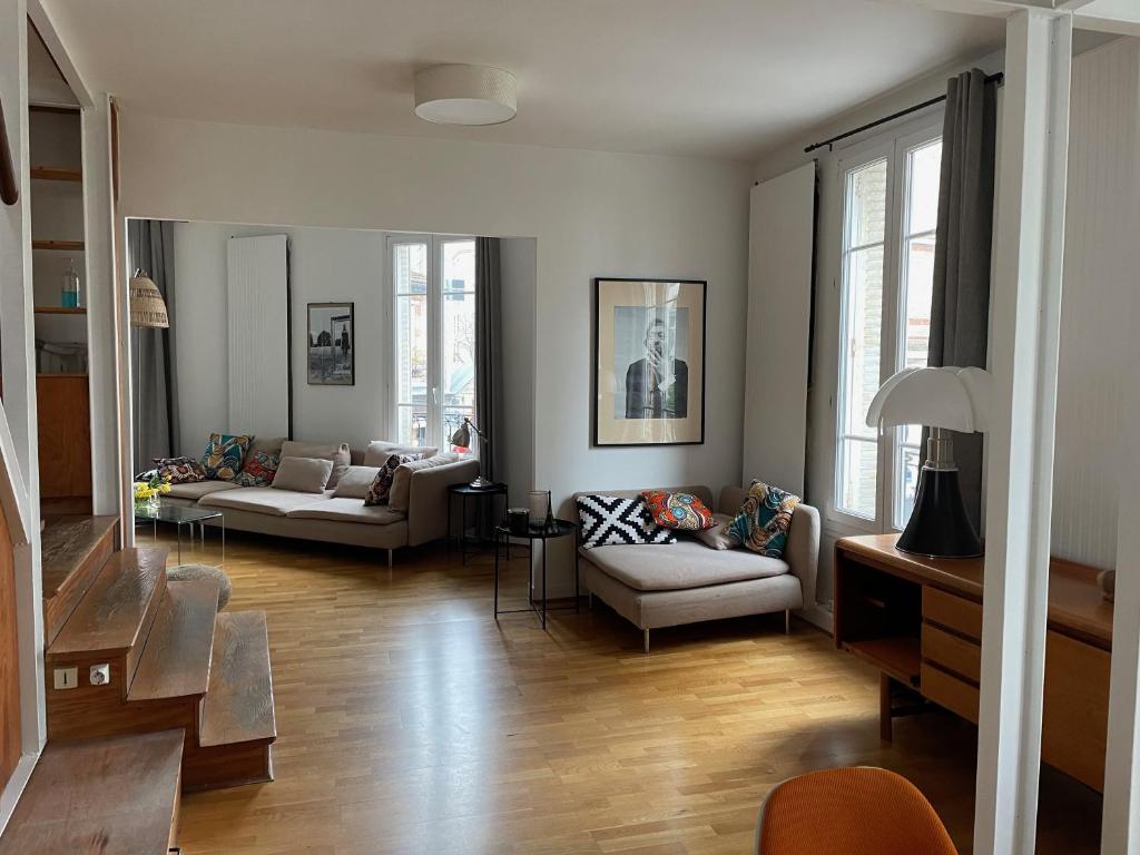 - un salon avec deux canapés et des chaises dans l'établissement Duplex - Butte aux Cailles, à Paris
