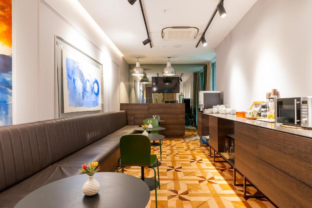 Breakfast buffet with coffee station, microwave and self-serve coffee station in a dining area with patterned tile and bench seating at MANDA Heritage Hotel in Zagreb